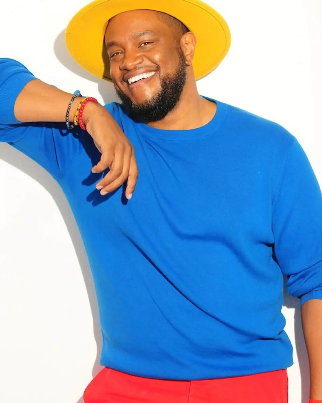 Tauheed looks dashing in a blue top and yellow hat as he poses for a picture