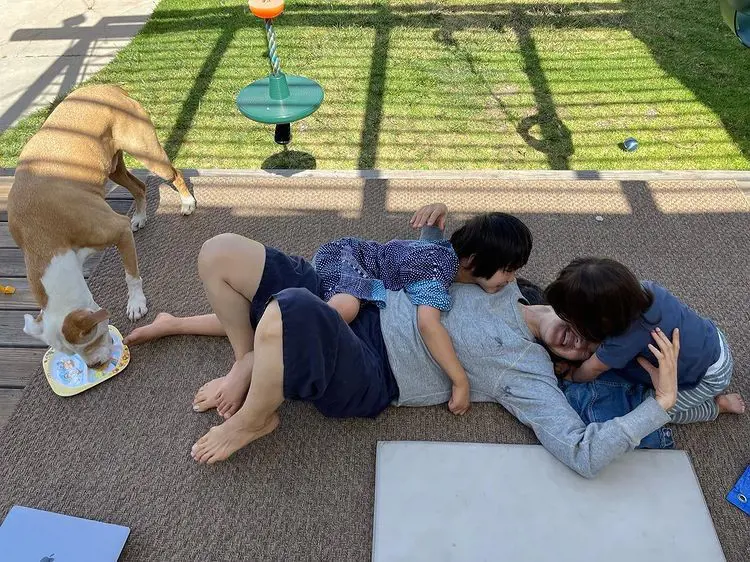 Jackie is having a fun time with her kids and dog.